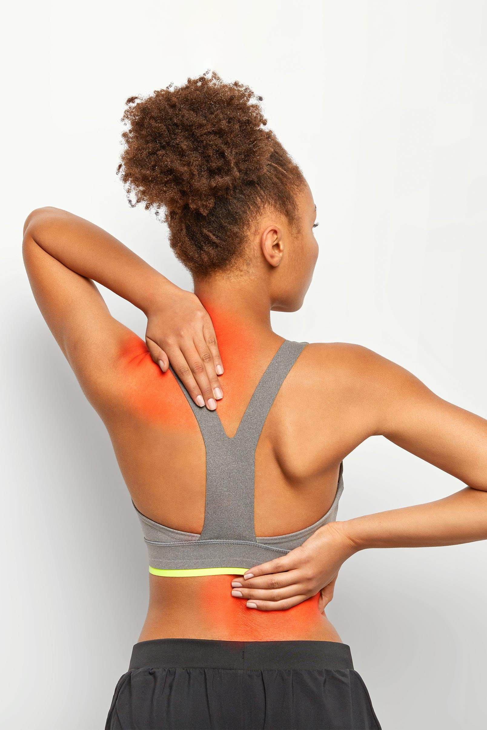 faceless curly woman suffers from spine pain wears sport bra shows location inflammation isolated white backgrounds