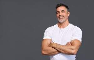 man standing with arms crossing smiling and thinking - Ageless MN: Are Peptides Steroids?