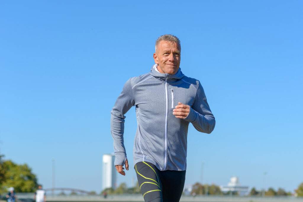 Front,View,Of,Gray,Smiling,Man,Wearing,Sportswear,Running,Along